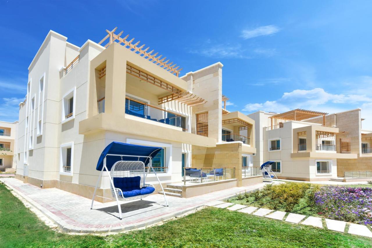 Tolip Resort El Galala Majestic Ain Sukhna Extérieur photo The photo displays a modern residential complex featuring two or more white buildings with a contemporary architectural design. Each building has balconies, large windows, and a sunshine-friendly layout that maximizes natural light. In the foreground