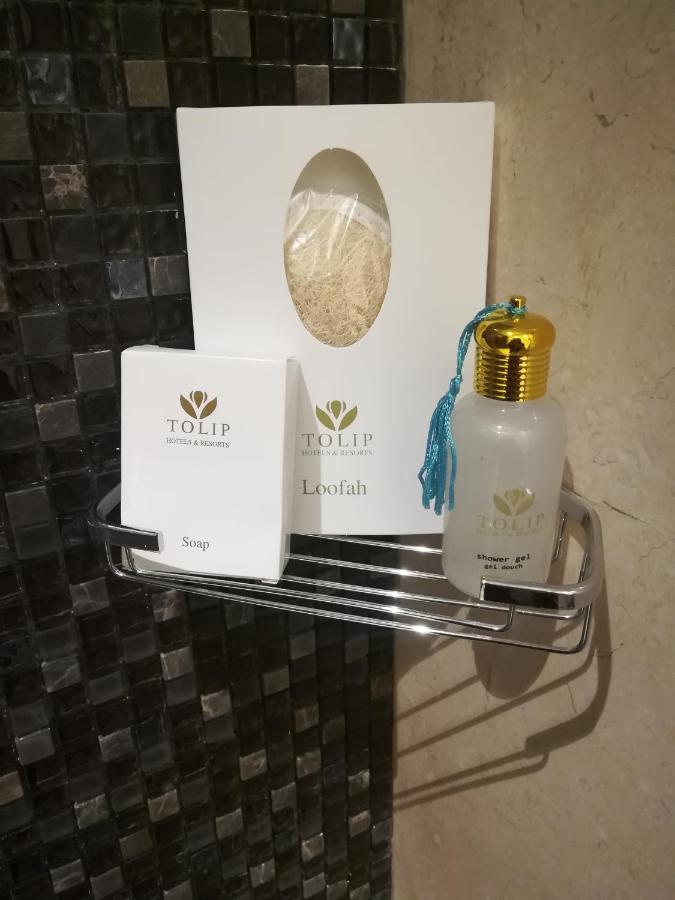 Tolip Resort El Galala Majestic Ain Sukhna Extérieur photo The photo shows a small metal shelf containing three items related to personal care. 

1. **Soap**: A white box labeled "TOLIP" with the word "Soap" visible on the front.
2. **Loofah**: A package with the same "TOLIP" branding, containing loofah.
3. 