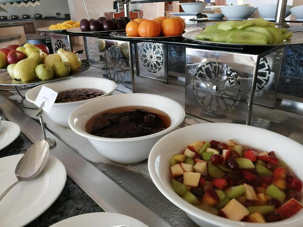 Tolip Resort El Galala Majestic Ain Sukhna Extérieur photo The photo shows a buffet-style arrangement of various fruits and fruit dishes. In the foreground, there are several bowls containing different types of fruit. One bowl has a fruit salad made with diced apples, green apples, and possibly other fruits.